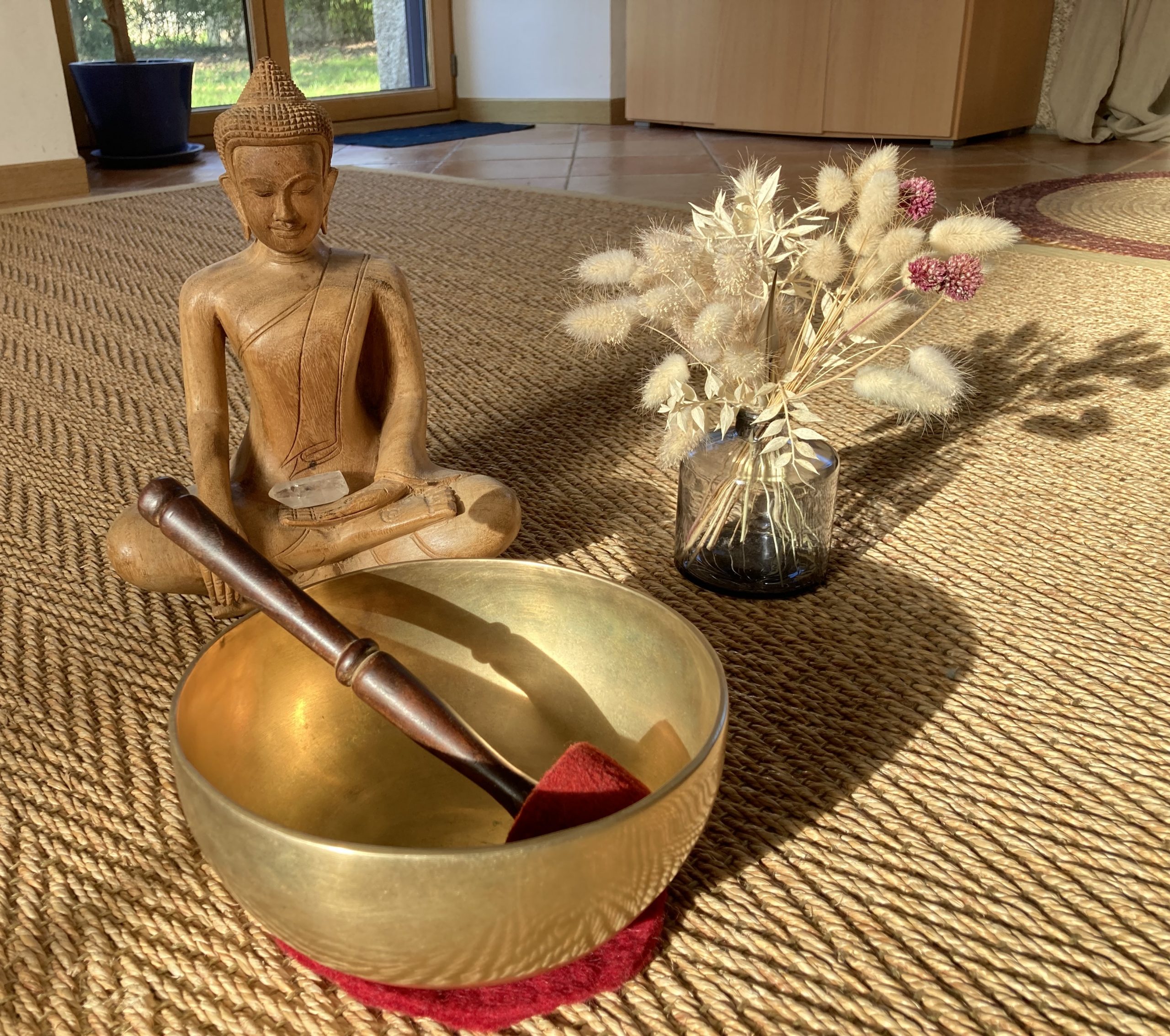 Photo d'un bol tibétain et d'une statuette en bois de Boudha